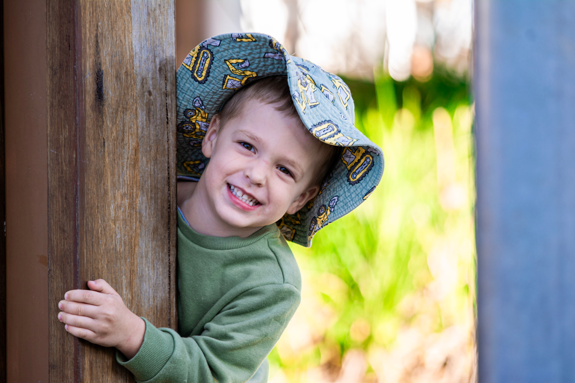 A child looking out from behind a timber post in the Emerald playscape